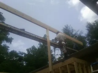Carpenter setting a ridge beam over a new addition frame — Ice Dam Removal by Roofing Brothers in Harveys Lake