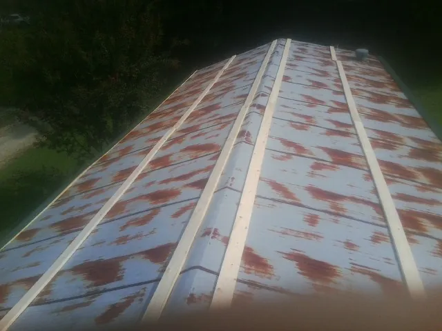 Rusted metal roof panels with new wood purlins before replacement — Storm Damage Roof Repair in Harveys Lake by Roofing Brothers