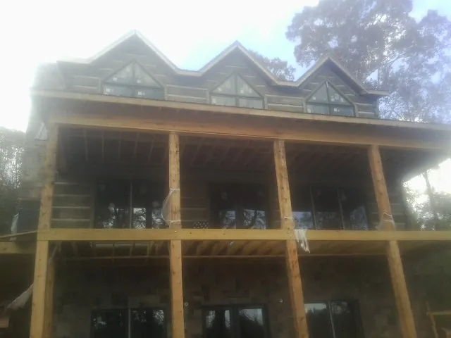 Dormers and porch framing on a large log home under construction — Roof Coating work by our crew in Harveys Lake