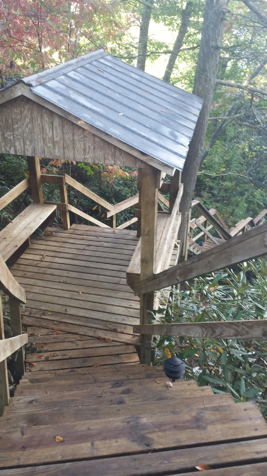 Metal roofed shelter over wooden steps on a wooded walkway — Skylight Repair & Installation work by our crew in Harveys Lake