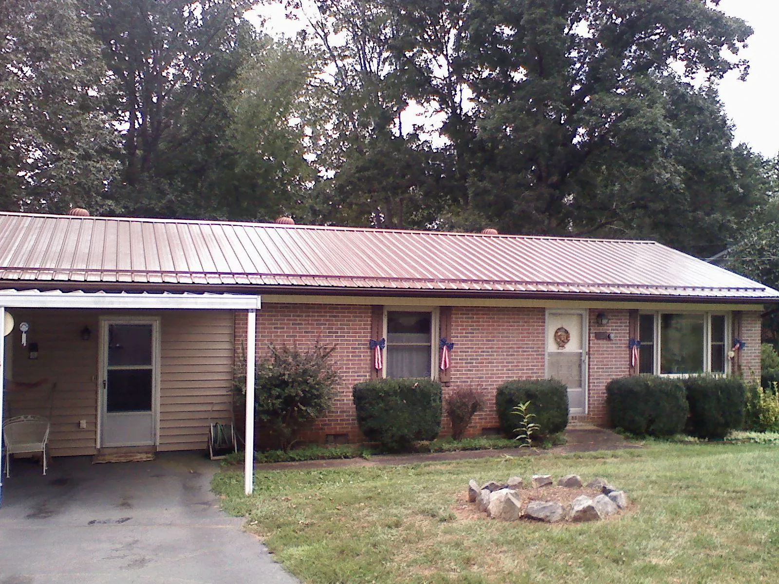 Bronze metal roof and carport on a brick ranch home — Roof Repair work by our crew in Harveys Lake